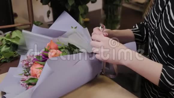 专业的花艺师用绸带系花束为国际妇女节准备美丽的花束视频的预览图