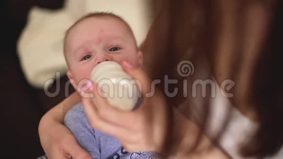 母亲把四个月大的婴儿抱在手上用奶瓶喂他牛奶视频的预览图