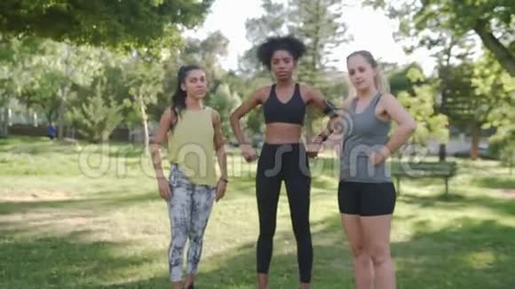 三位多种族自信的年轻女性朋友在公园镜头前摆姿势的画像视频的预览图