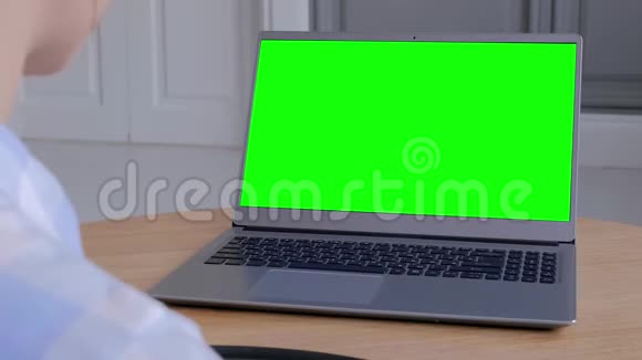 侧肩视图女性看绿色显示器的笔记本电脑模型概念视频的预览图