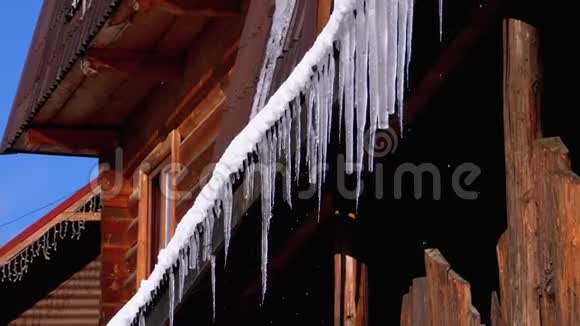 冰柱融化滴在挂在木屋屋顶上的太阳上慢动作视频的预览图