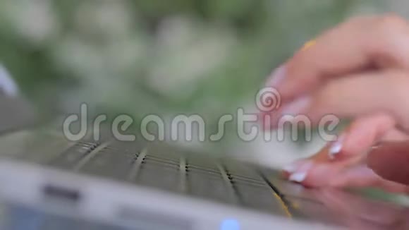 女士手在笔记本电脑键盘上打字背景是bokeh光视频的预览图