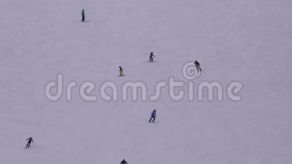 在阳光明媚的日子里滑雪者和滑雪者在滑雪场的雪坡上骑马视频的预览图