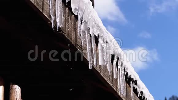 冰柱融化滴在挂在木屋屋顶上的太阳上慢动作视频的预览图