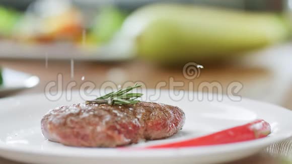 把盐洒在开胃的牛肉片上放在盘子上慢动作近距离拍摄4k红色相机视频的预览图