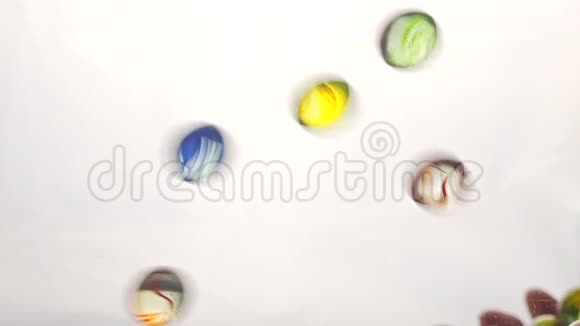 从下面的视图因为手抛出小的多色塑料球白色背景视频的预览图