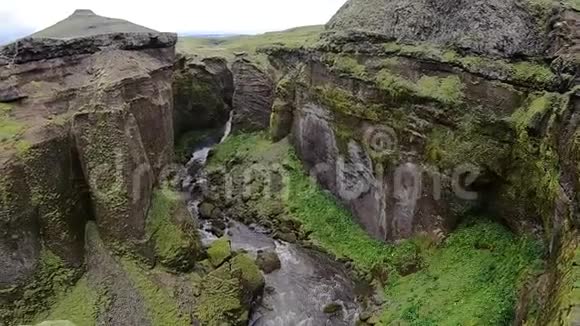 美丽的河流在冰岛峡谷周围的绿色悬崖上的Fimvorduhals徒步旅行轨道视频的预览图