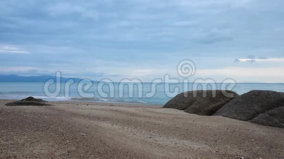 蓝天背景下日落时带石的桑迪海岸视频的预览图