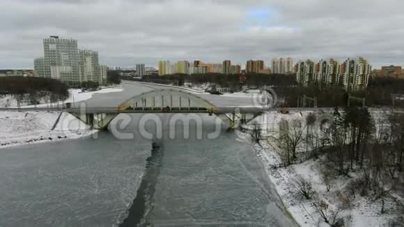鸟瞰美丽的城市景观铁路大桥跨越冰冻的河流视频的预览图