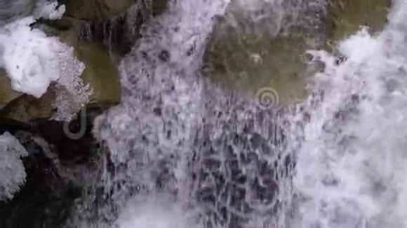 山溪和石急流与雪水的快速流动冬天的瀑布慢动作视频的预览图