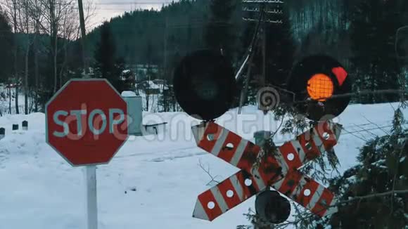 在冬季的一个森林里的铁路十字路口红色闪光交通灯列车通过视频的预览图