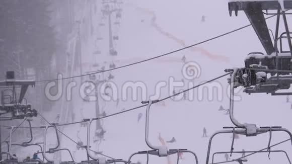 滑雪场滑雪电梯滑雪者在滑雪椅电梯上爬上滑雪坡伴着降雪视频的预览图