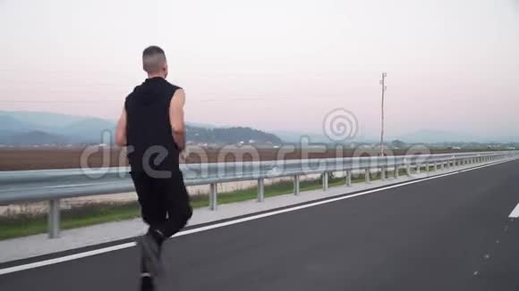 4k跟随年轻健康男子在空街慢跑的视频视频的预览图
