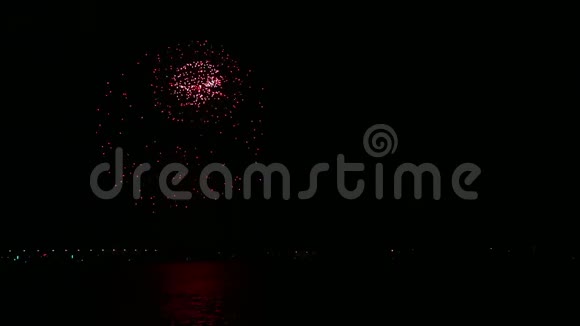 明亮明亮的节日烟花在夜空中映照在水面上视频的预览图