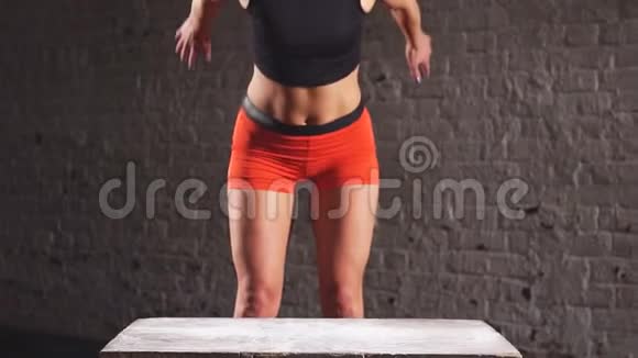 关闭运动女子做盒子跳跃在废弃的工厂健身房视频的预览图