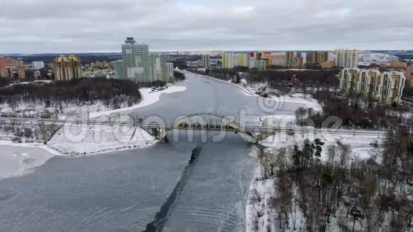 鸟瞰美丽的城市景观铁路大桥跨越冰冻的河流视频的预览图