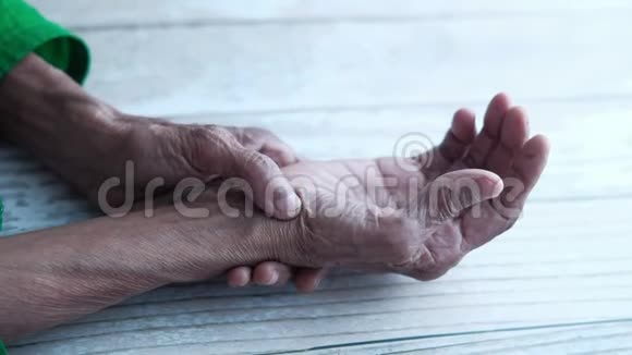 年长女性摩擦手腕和拇指视频的预览图