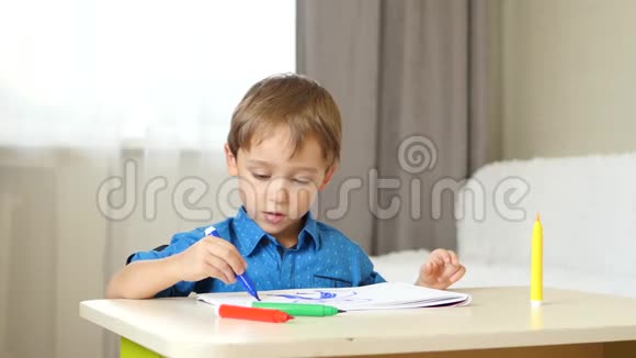 一个欧洲貌美的男孩坐在他房间的一张桌子旁花时间画画儿童想象绘画视频的预览图
