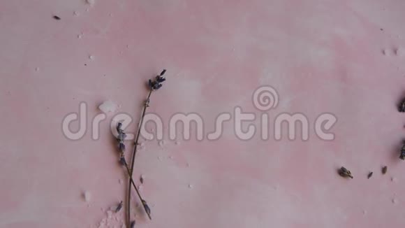 粉红色背景上的天然健康美容成分海盐和薰衣草的保健水疗疗法视频的预览图