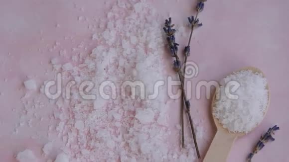 粉红色背景上的天然健康美容成分海盐和薰衣草的保健水疗疗法视频的预览图