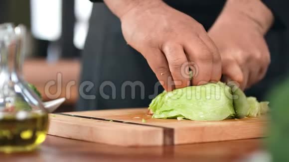 厨师工人手在厨房桌子上切绿色生菜叶近距离拍摄4k红色相机视频的预览图