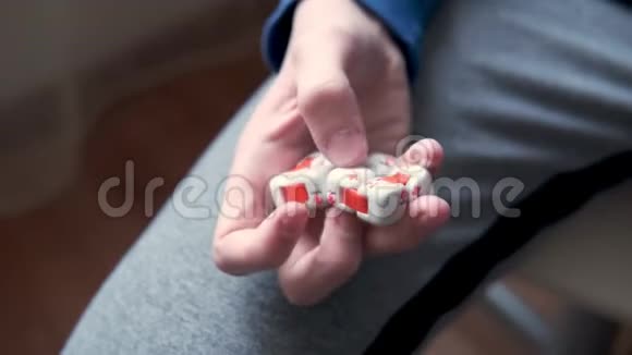 五颜六色的手指在小男孩手中抗压力坐立不安的立方体玩具发展儿童手指精细运动技能视频的预览图