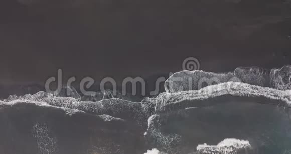 空中观景黑色沙滩美丽的海浪拍打着海岸线加那利特内利天然火山滩视频的预览图