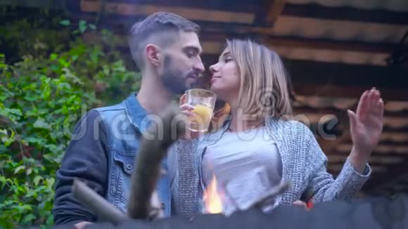 快乐的白种人夫妇站在烧烤的地方在户外喝酒拥抱和亲吻有爱的男人和女人视频的预览图