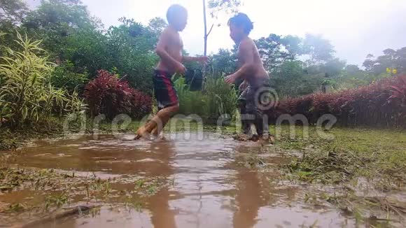 土著儿童在亚马逊村的水坑里摔跤视频的预览图