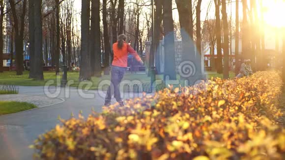 在舒适的城市公园里一个专业的男滑轮者在溜冰鞋上表演酷酷的技巧和舞蹈视频的预览图
