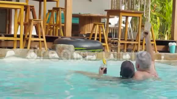 可爱的成人夫妇要求更多的饮料享受游泳池视频的预览图