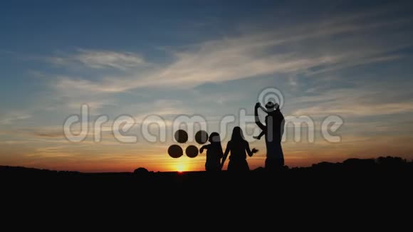 剪影日落时带气球的家庭视频的预览图