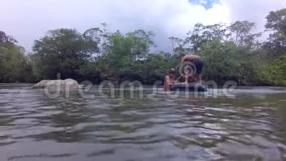 三个土著儿童试图站在漂浮的内筒里视频的预览图