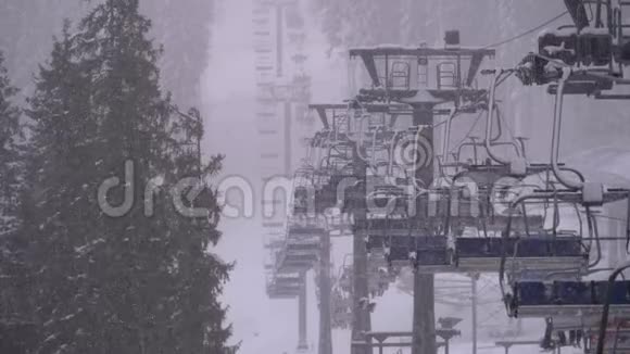 滑雪场滑雪电梯慢动作滑雪者爬上滑雪椅电梯到滑雪坡与落雪视频的预览图