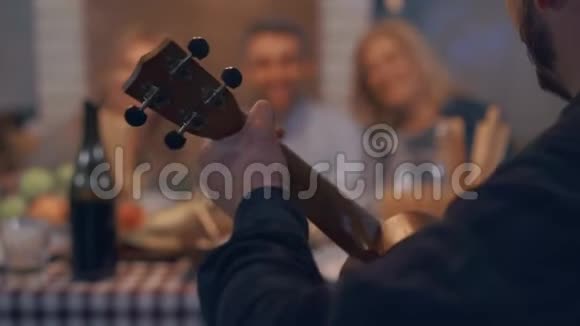 人在前台弹吉他招待大家邻居或亲戚晚上视频的预览图