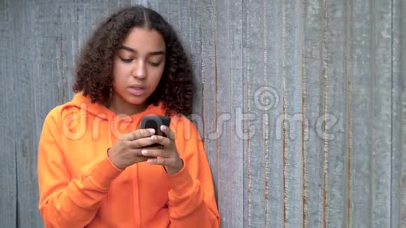 非洲裔美国少女年轻女性使用智能手机或手机在社交媒体上显得悲伤或体贴视频的预览图