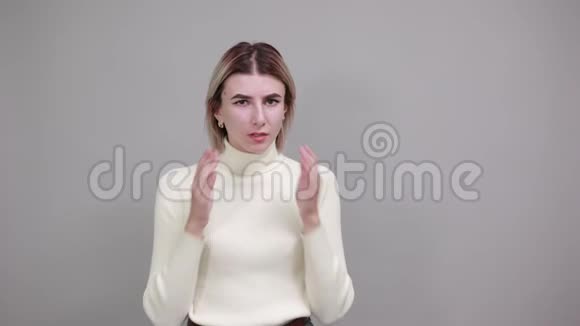 穿着休闲服的无聊女人用手指探着手背在头上视频的预览图