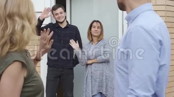 幸福的家庭站在门口挥手而他们的客人离开可爱的高加索邻居告别视频的预览图