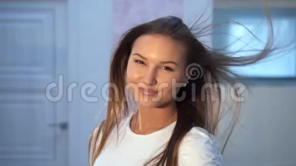 美丽的女人微笑着风吹着她的头发视频的预览图