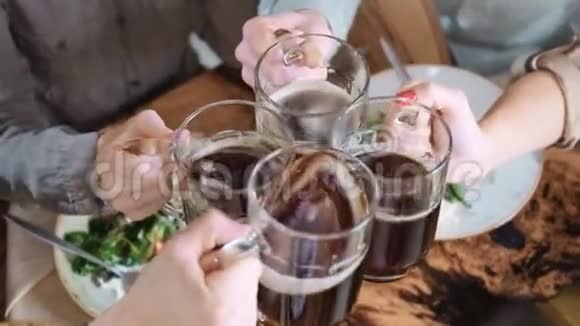 朋友用啤酒在桌子上敲打玻璃食物动作缓慢拍摄红色镜头视频的预览图