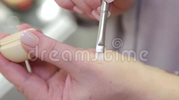 专业化妆师从一个奶油罐里拿起唇霜视频的预览图