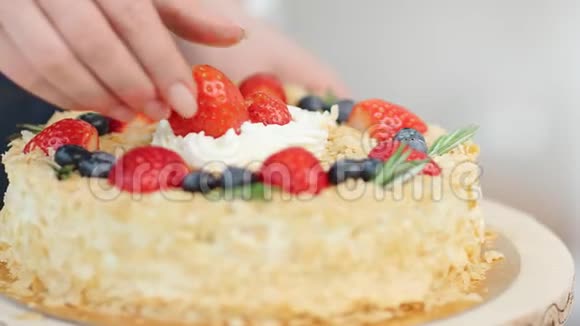合上女厨师的手臂把整个和半个新鲜草莓放在蛋糕上4k龙红相机视频的预览图