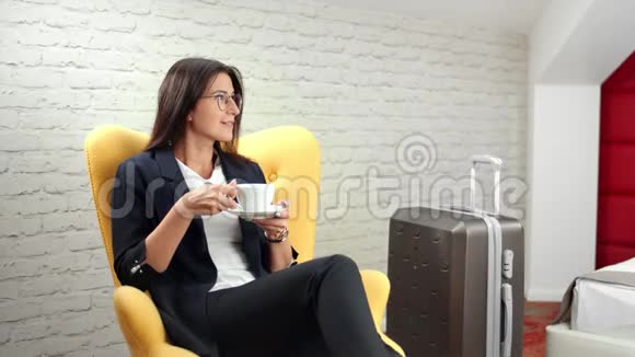 在商务旅行中微笑放松的女商人喝咖啡享受休息视频的预览图