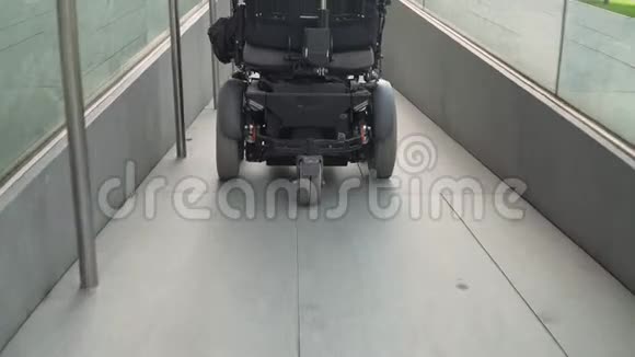 使用坡道的电动轮椅上的男子的4k分辨率后视图无障碍概念视频的预览图
