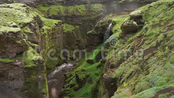缓慢的运动美丽的河流在绿色的峡谷与小瀑布在冰岛视频的预览图