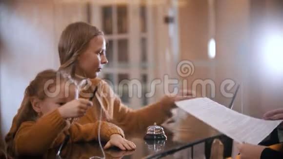 一家住在豪华酒店的家庭一个小女孩在妈妈拿着铅笔签名之前玩着铅笔视频的预览图