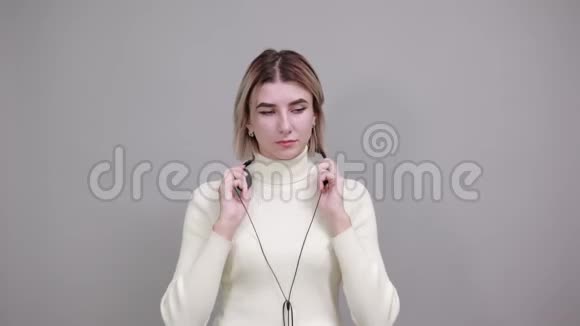 女士使用无线耳机在听音乐时唱歌和娱乐视频的预览图