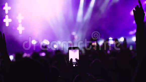 音乐迷在音乐会上的人群中电话录制视频慢动作视频的预览图