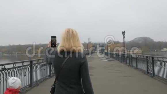 一个女人和她的小女儿走过桥在视频聊天中交谈一个有影响力的人把视频的预览图