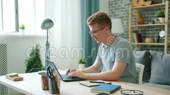 在家学习的男学生使用笔记本电脑打字然后用笔记本电脑写作视频的预览图